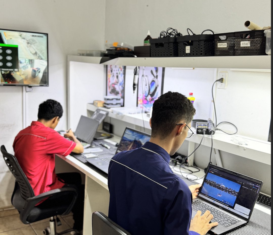 Bancada de manutenção com técnicos reparando notebooks